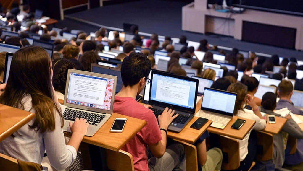 amphithéâtre rempli d'étudiants sur leurs ordinateurs