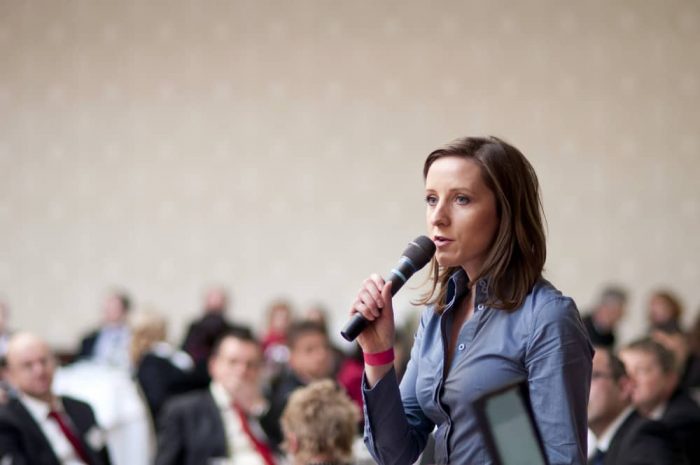 femme tenant une conférence devant un public