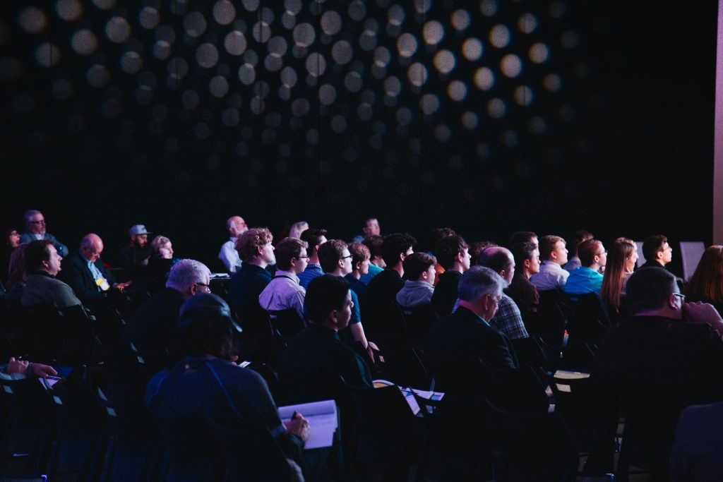 salle de conférence sombre avec public