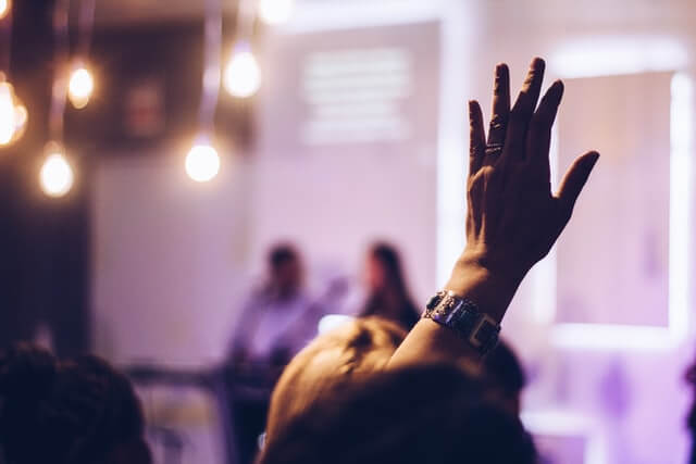 salle de conférence avec personne levant la main