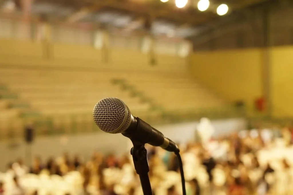 salle de conférence avec foule et microphone au premier plan